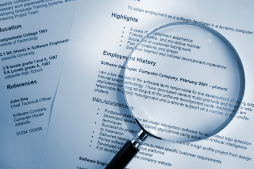 magnifying glass on top of resume paper